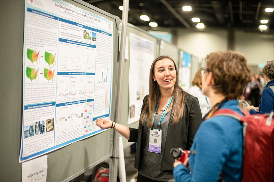 Woman explains poster to another woman attendee Woman explains poster to another woman attendee