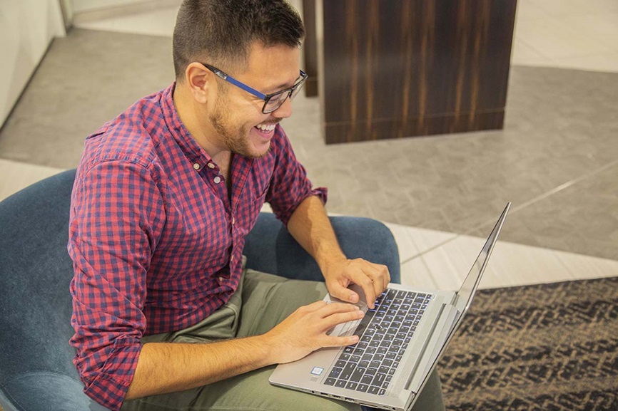 man smiling and typing on computer man smiling and typing on computer
