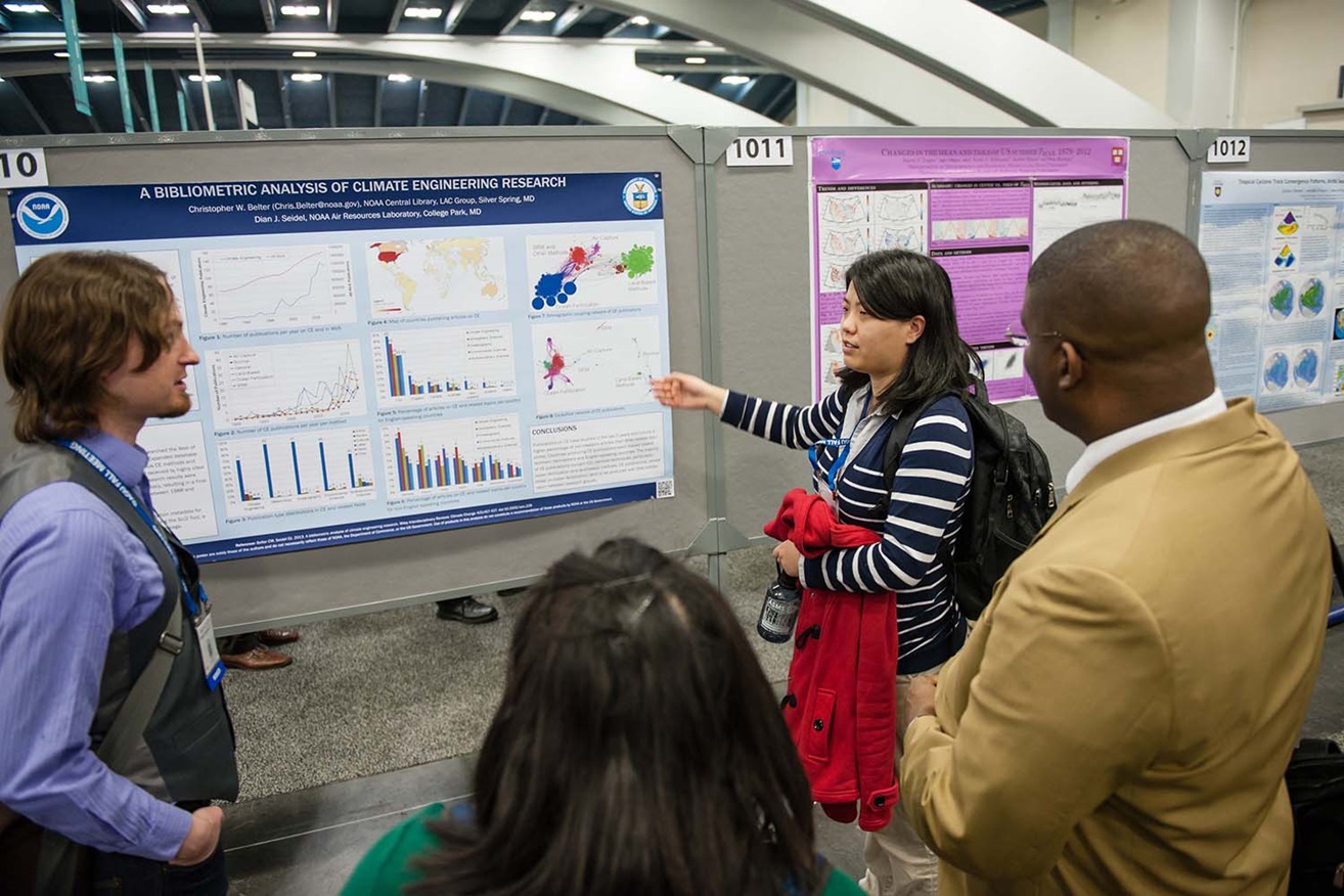 woman pointing and explaining poster to audience woman pointing and explaining poster to audience